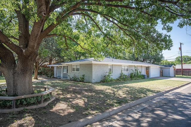 single story home featuring a garage, a front yard, and central AC unit