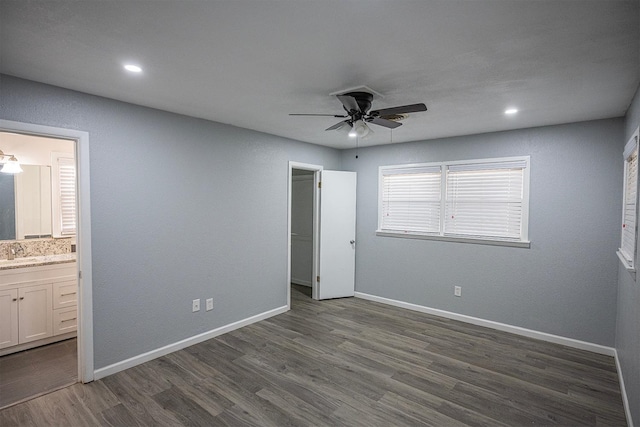 unfurnished bedroom featuring ceiling fan, sink, connected bathroom, and dark hardwood / wood-style flooring