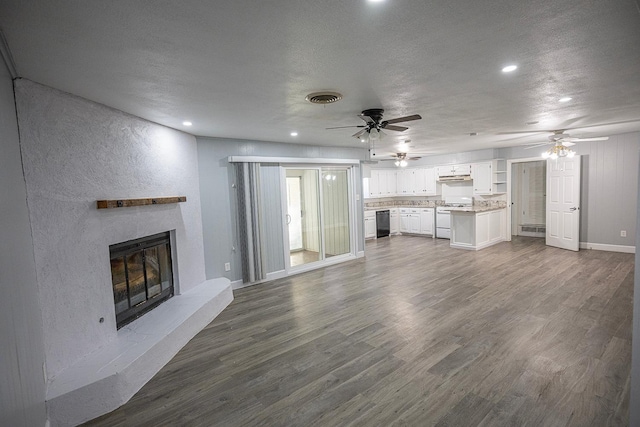 unfurnished living room with ceiling fan, dark wood-type flooring, and a textured ceiling