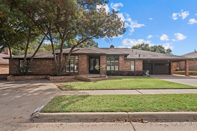 ranch-style house featuring a garage and a front lawn