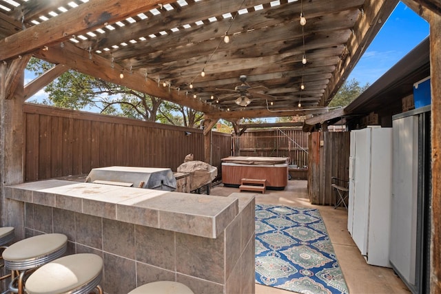 view of patio / terrace with an outdoor bar, ceiling fan, a hot tub, and area for grilling