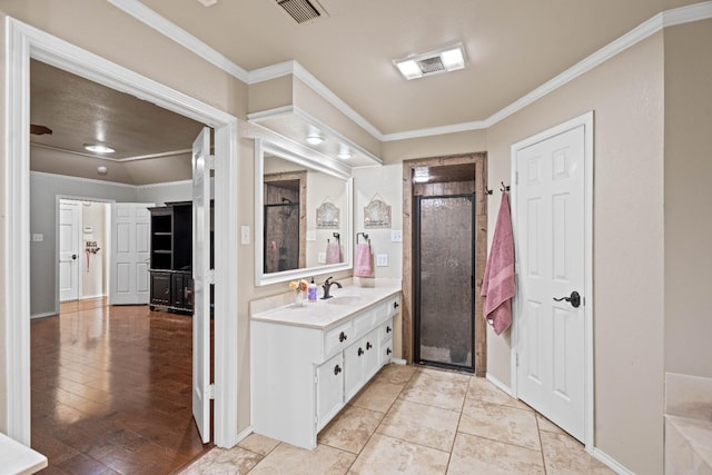 bathroom featuring vanity, ornamental molding, and a shower with door