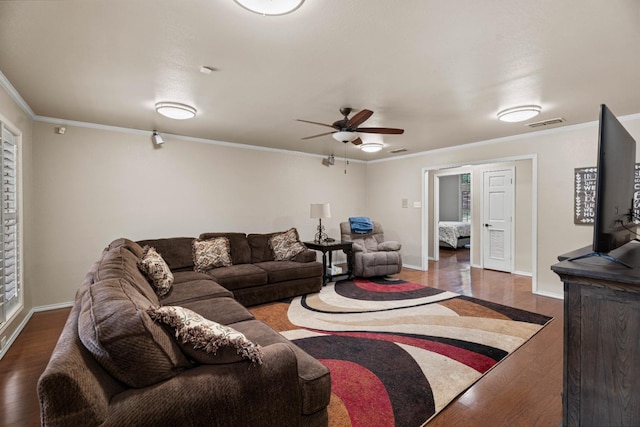 living room featuring dark wood-type flooring, ornamental molding, and ceiling fan