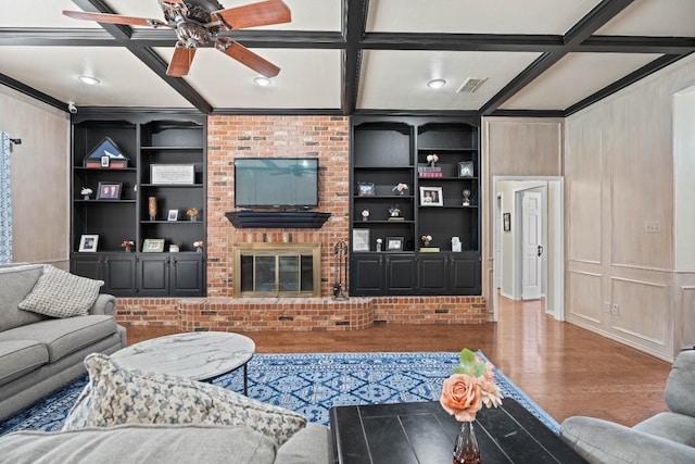 living room featuring coffered ceiling, a fireplace, built in features, and dark hardwood / wood-style floors