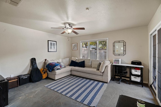 living room featuring ceiling fan and a textured ceiling