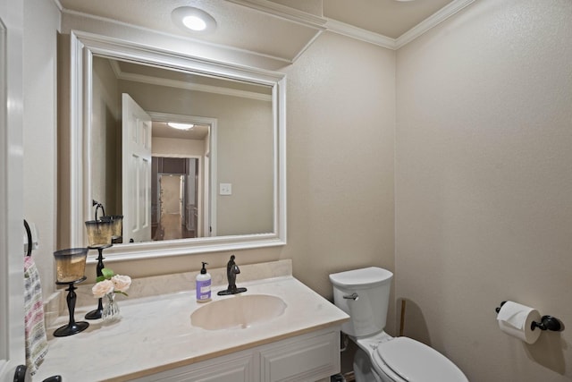 bathroom with crown molding, vanity, and toilet