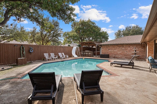 view of swimming pool with a patio and a water slide