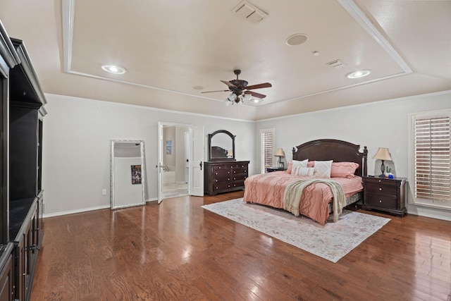 bedroom featuring crown molding, dark hardwood / wood-style floors, and a raised ceiling