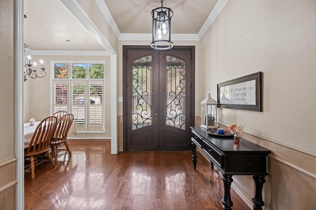 entryway featuring french doors, an inviting chandelier, crown molding, and dark wood-type flooring