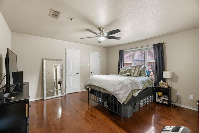 bedroom featuring ceiling fan, dark hardwood / wood-style flooring, and a textured ceiling