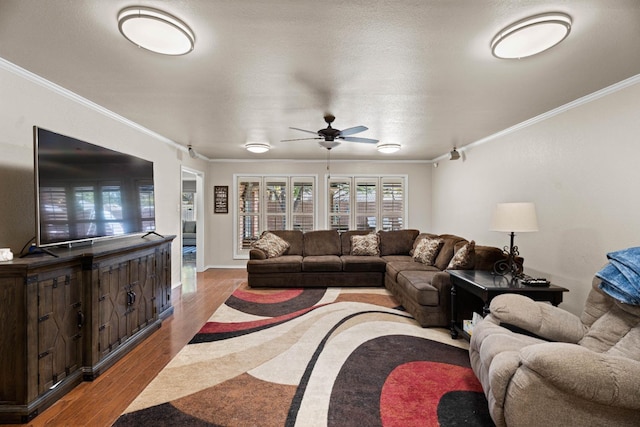 living room with crown molding, ceiling fan, and light wood-type flooring