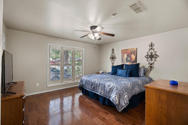 bedroom featuring ceiling fan, a textured ceiling, and dark hardwood / wood-style flooring