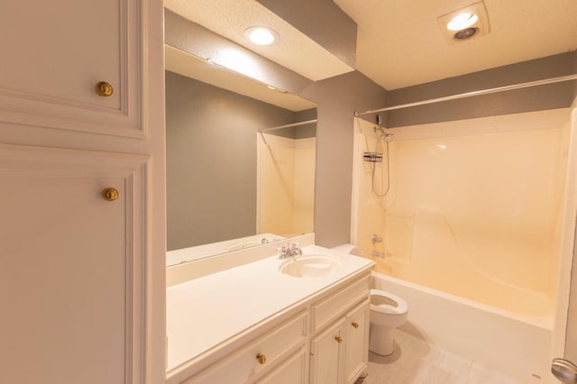 full bathroom with vanity, a textured ceiling, toilet, and washtub / shower combination