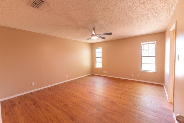 empty room with hardwood / wood-style floors, a textured ceiling, and ceiling fan