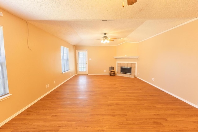 unfurnished living room featuring ceiling fan, vaulted ceiling, light hardwood / wood-style flooring, and a textured ceiling