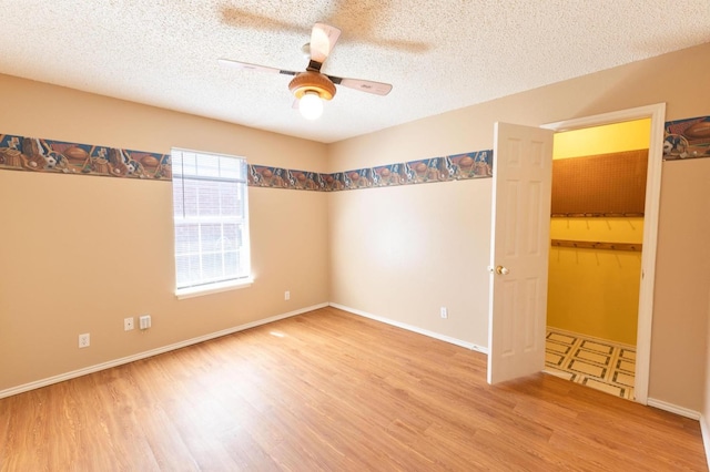 unfurnished room with ceiling fan, hardwood / wood-style flooring, and a textured ceiling