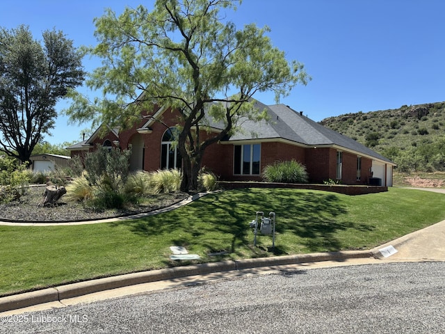 1 Squaw Ln, Ransom Canyon, TX 79366 - view of front facade with a garage, brick siding, a front yard, and driveway