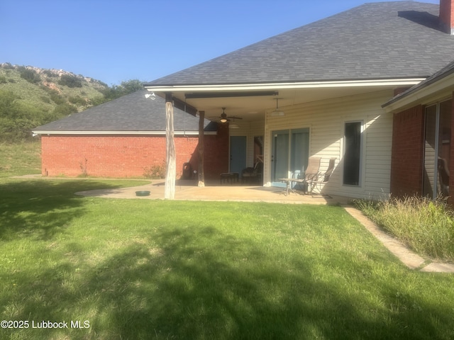 1 Squaw Ln, Ransom Canyon, TX 79366 - rear view of property featuring a ceiling fan, a lawn, a patio area, roof with shingles, and a chimney