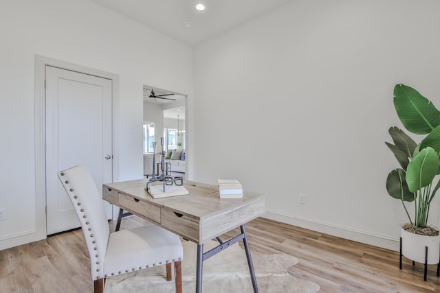 office with light hardwood / wood-style flooring and ceiling fan