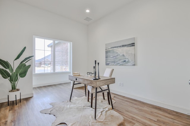 home office with light hardwood / wood-style flooring