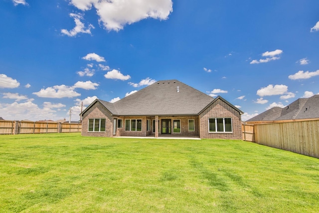 rear view of house featuring a yard