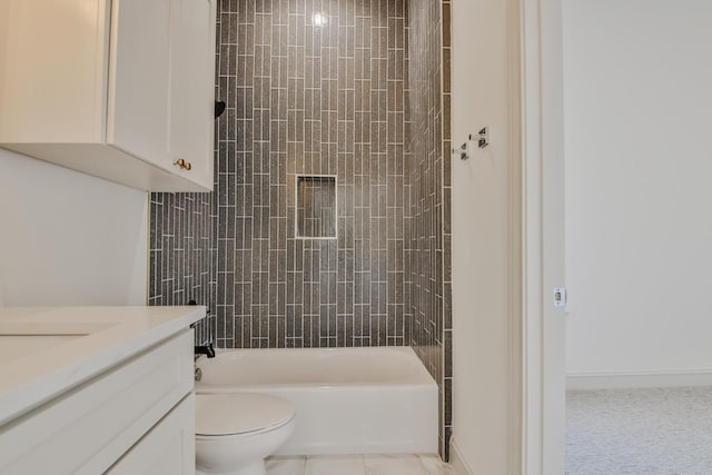 full bathroom featuring tiled shower / bath, vanity, and toilet