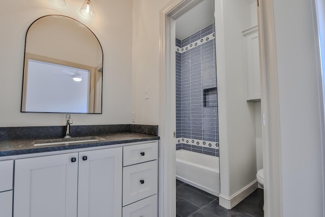 full bathroom featuring tile patterned flooring, vanity, tiled shower / bath combo, and toilet