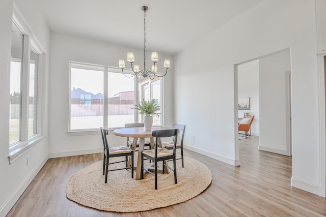 dining area with a notable chandelier, light hardwood / wood-style floors, and a healthy amount of sunlight