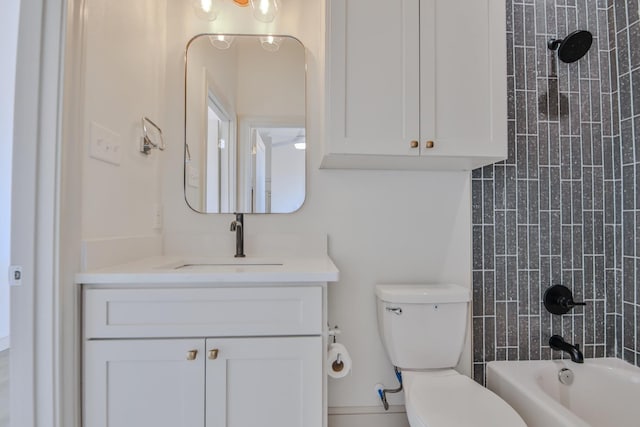 full bathroom featuring tiled shower / bath, vanity, and toilet