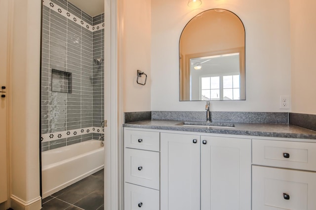 bathroom featuring tile patterned flooring, tiled shower / bath, and vanity