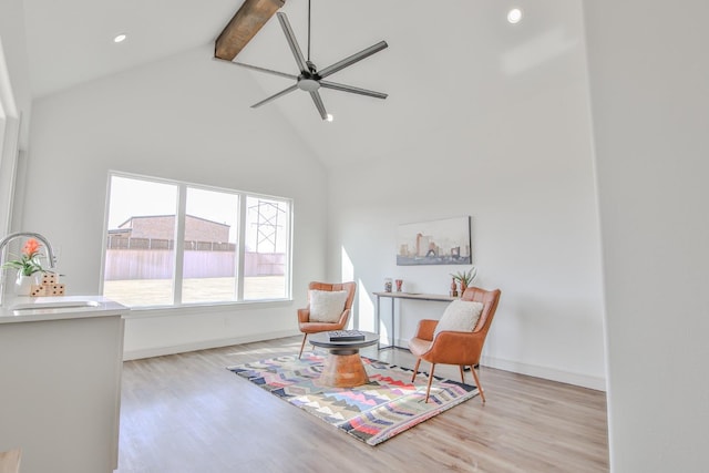 living area with sink, ceiling fan, beam ceiling, high vaulted ceiling, and light hardwood / wood-style floors