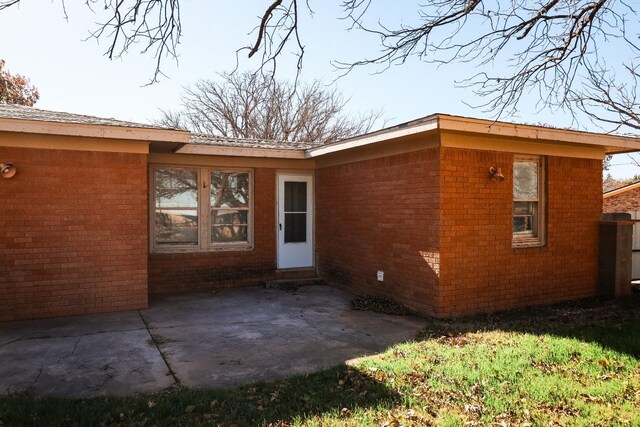 view of exterior entry featuring a patio area