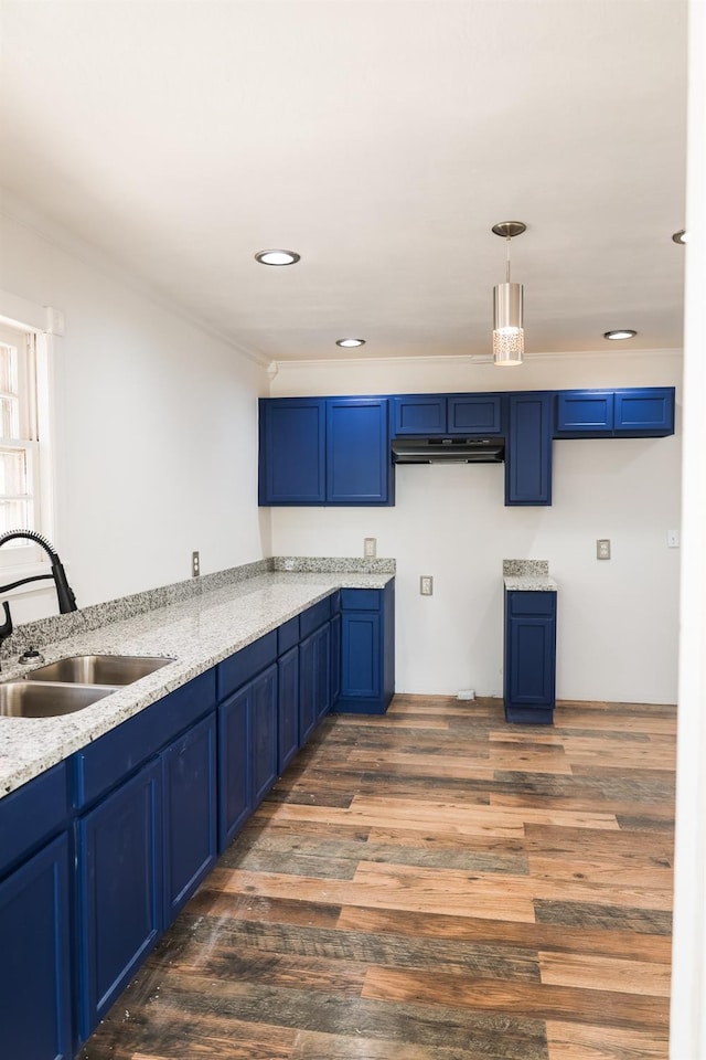 kitchen with blue cabinetry, sink, dark hardwood / wood-style floors, pendant lighting, and light stone countertops