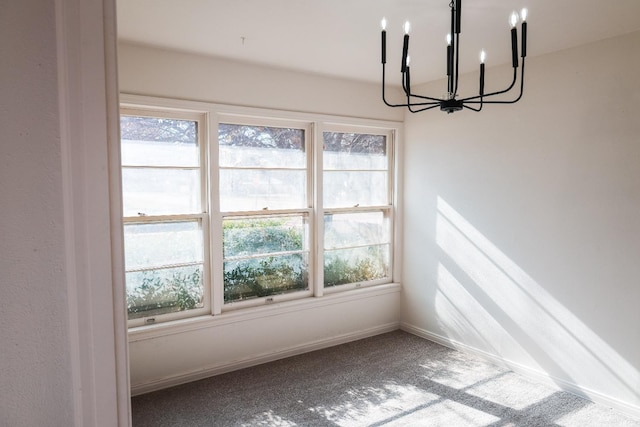 unfurnished dining area featuring an inviting chandelier and carpet