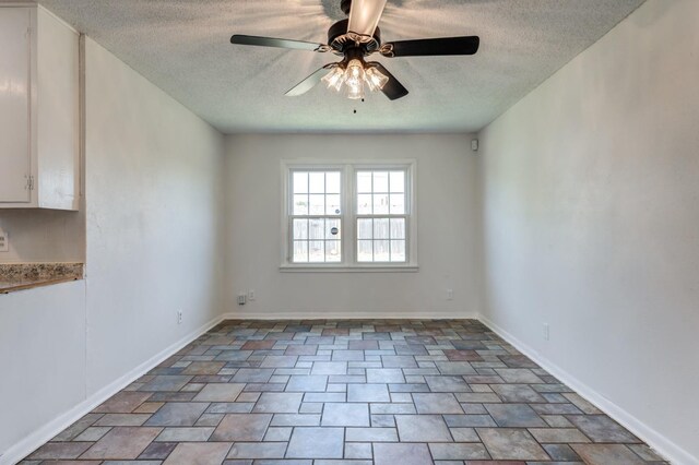 spare room with ceiling fan and a textured ceiling