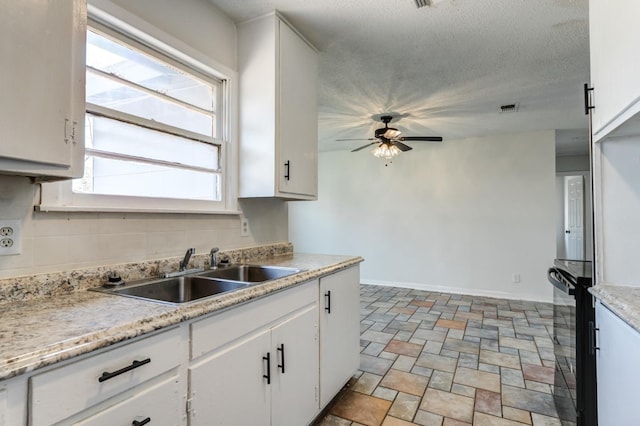 kitchen with sink, tasteful backsplash, a textured ceiling, ceiling fan, and white cabinets