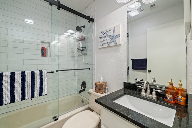 full bathroom featuring enclosed tub / shower combo, vanity, and toilet