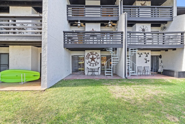 rear view of property featuring a patio, a balcony, ceiling fan, and a lawn