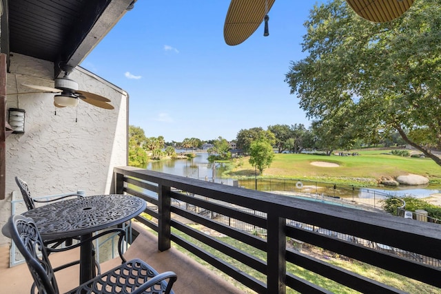 balcony featuring ceiling fan and a water view