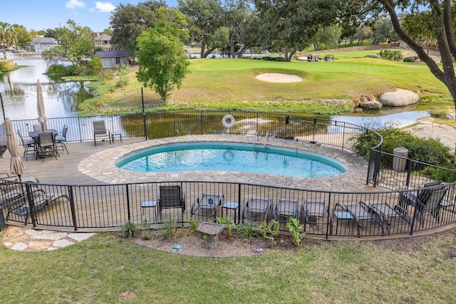 view of swimming pool featuring a lawn and a water view