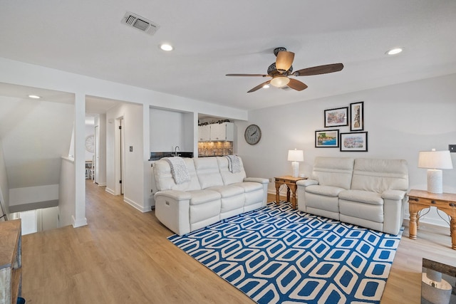 living room with ceiling fan and light hardwood / wood-style floors