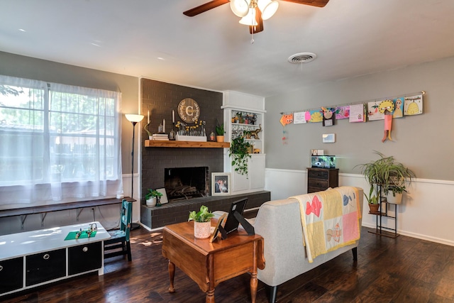 living area featuring visible vents, wood finished floors, a ceiling fan, and a fireplace