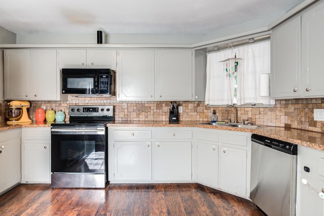 kitchen featuring stainless steel appliances, decorative backsplash, white cabinets, and a sink