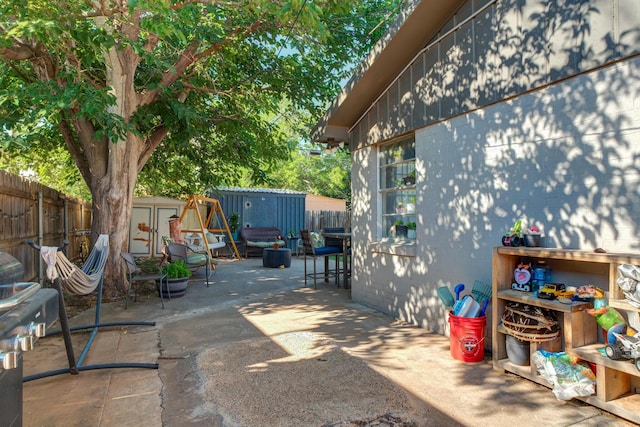 view of patio / terrace with an outbuilding, a shed, and a fenced backyard