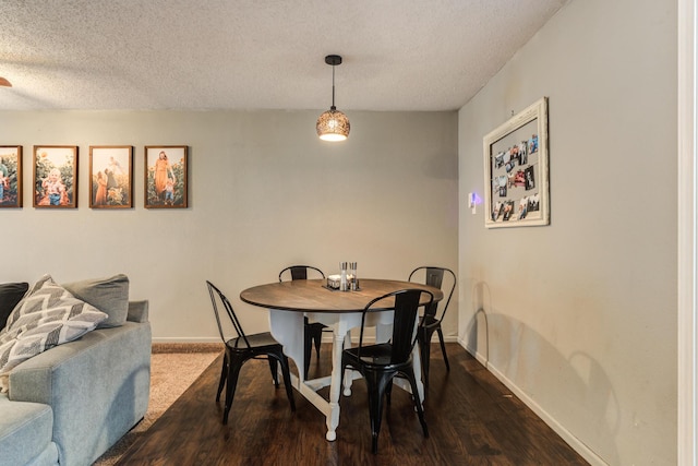 dining room with baseboards, a textured ceiling, and dark wood-style flooring