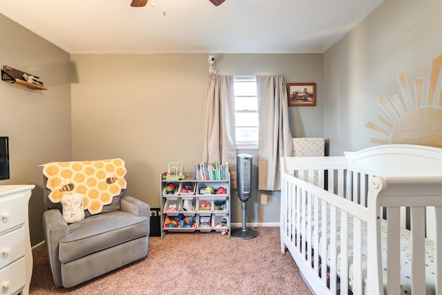 bedroom featuring a crib, ceiling fan, and carpet