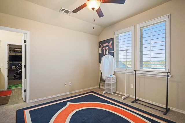 unfurnished bedroom with ceiling fan, vaulted ceiling, and carpet