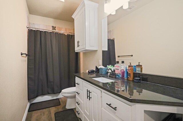 bathroom featuring hardwood / wood-style flooring, vanity, a shower with curtain, and toilet