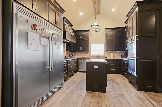 kitchen with tasteful backsplash, hanging light fixtures, a center island, stainless steel appliances, and light wood-type flooring