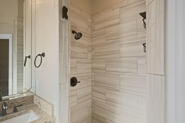 bathroom with vanity and tiled shower